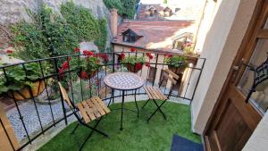 Un balcón con una mesa y sillas en el césped en Red Lion Pub & Apartments Szentendre, en Szentendre