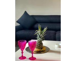 zwei rosa Weingläser und eine Ananas auf dem Tisch in der Unterkunft OTEL374 in Bolu