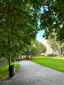 a woman walking down a path in a park at Eteläinen Hesperiankatu in Helsinki