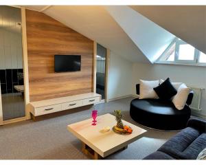 a living room with a black couch and a tv at OTEL374 in Bolu