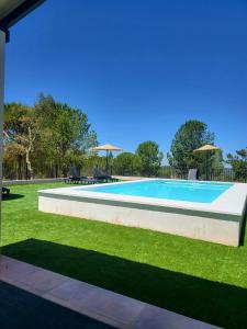 una gran piscina en un patio con césped en Finca La Caprichosa, en Cortelazor
