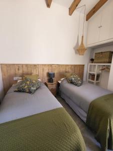 1 dormitorio con 2 camas y mantas verdes en Finca La Caprichosa, en Cortelazor