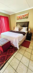 a bedroom with a large bed and red curtains at Mthandi Wokuhamba Lodge in Dundee