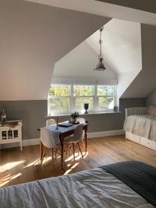 a bedroom with a table and chairs and a bed at LymingtonBnB in Lymington