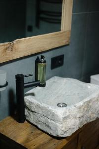 a bathroom counter with a marble sink with a mirror at Hotel Dynasty in Kamianets-Podilskyi