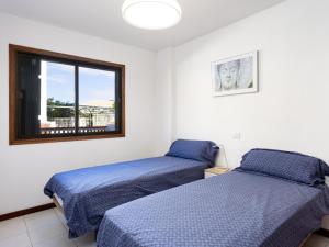 two beds in a room with a window at Live cardon las americas con piscina y terraza in Arona
