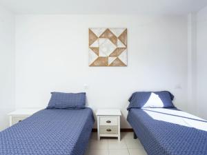 a bedroom with two beds and a picture on the wall at Live cardon las americas con piscina y terraza in Arona