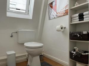 a bathroom with a toilet and a window and towels at Exclusives Wohnen im Centrum Oldenburgs in Oldenburg