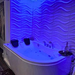 una vasca da bagno in una stanza con luci blu di BeB Boreale a Napoli