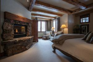 a large bedroom with a stone fireplace and a bed at 866 Bachelor Ridge in Edwards