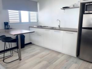 a kitchen with white cabinets and a sink and a table at Secret View in Isabela