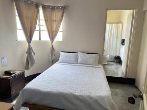 a bedroom with a large bed and a bathroom at Hotel Mayesstic in Guatemala