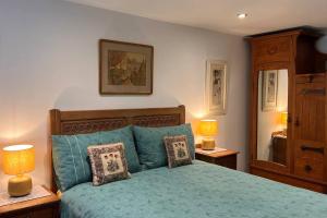 a bedroom with a green bed with two lamps at Charming Galloway cottage near Kirkcudbright in Twynholm