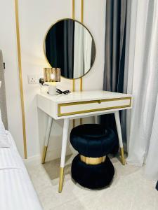 a vanity with a mirror and a stool under a table at KLCC Suites At Axon Residence in Kuala Lumpur