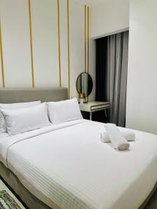 a bedroom with a large white bed with towels on it at KLCC Suites At Axon Residence in Kuala Lumpur