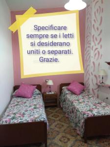 2 posti letto in una camera con un cartello sul muro di Bed & Breakfast Paui a Càbras
