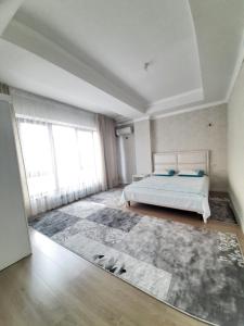 ein Schlafzimmer mit einem Bett und einem großen Teppich in der Unterkunft Comfortable apartment in Bischkek