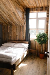 1 dormitorio con cama y ventana en Hotel Dynasty, en Kamianets-Podilskyi
