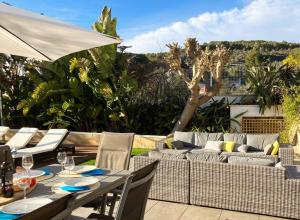 un patio con mesa, sillas y sofá en Tranquil and spacious 5 bedroom family villa, en Sant Pere de Ribes