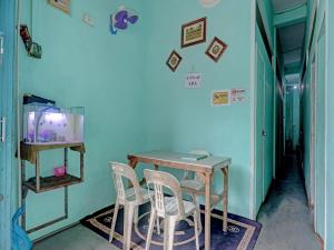 une table et des chaises dans une pièce dotée d'un mur bleu dans l'établissement SPOT ON 92985 Mitra Homestay, à Nagoya