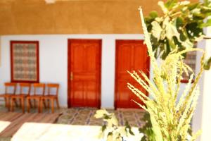 twee deuren van een huis met stoelen en een tafel bij gîte d'étape ziz oasis in Achbarou