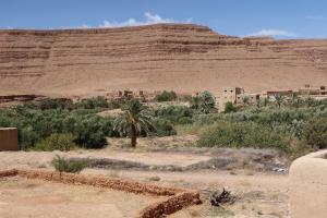 een dorp in de woestijn met een berg op de achtergrond bij gîte d'étape ziz oasis in Achbarou