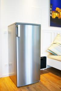 a stainless steel refrigerator in a room with a bed at Apartments Rummelsburger Bucht am Ostkreuz in Berlin