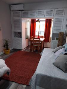 1 dormitorio con mesa, cama y alfombra en Edificio Punta del Este, en Punta del Este