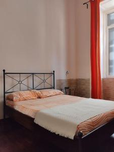 拿坡里的住宿－La scalinata apartment，一间卧室配有一张带橙色窗帘的床