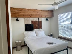 1 dormitorio con cama blanca y ventana en Blanco County Inn & Guesthouses en Blanco