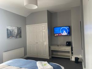 a bedroom with a bed and a tv on the wall at Feildens Arms & Hotel in Balderstone