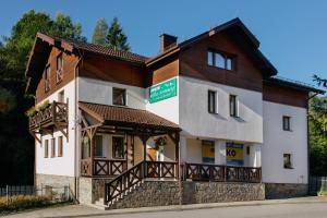 a large white building with wooden accents at Antracyt in Krynica Zdrój