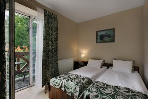 a bedroom with a bed and a sliding glass door at Antracyt in Krynica Zdrój