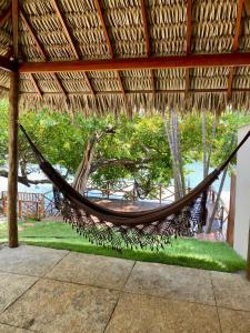 a hammock hanging from a straw roof at Pousada Casa Dunas in Barreirinhas