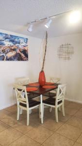 a dining room table with a vase on top of it at Tranquil Condo, located in Coconut Creek, Florida in Coconut Creek