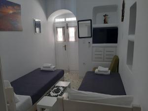 a small room with two beds and a door at Room to rent 2 in Mikonos