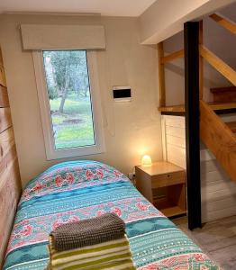 a small bedroom with a bed and a window at Casita Silvestre y Casa Rosa in Villa La Angostura