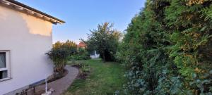 a garden next to a white building and a yard at Ferienhaus Elisabeth in Leutkirch im Allgäu