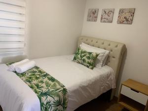 - une petite chambre avec un lit doté d'une tête de lit et d'oreillers dans l'établissement Apartamentos San Jose vistal al lago, cerca del parque. Guatape., à Guatapé