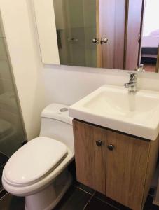 La salle de bains est pourvue de toilettes blanches et d'un lavabo. dans l'établissement Apartamentos San Jose vistal al lago, cerca del parque. Guatape., à Guatapé