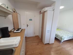 een keuken met een gootsteen en een kamer met een bed bij Una in Umag