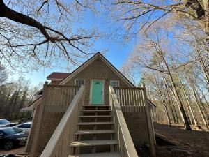 una pequeña casa con una escalera que conduce a una puerta verde en 3196 Joe Parker C, en Gainesville