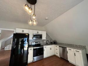 eine Küche mit weißen Schränken und einem schwarzen Kühlschrank in der Unterkunft 3196 Joe Parker C in Gainesville