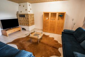 a living room with a couch and a coffee table at Ferienwohnung Bayerwaldblick Hexental in Bogen +13 photos