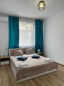 Schlafzimmer mit einem großen Bett und blauen Vorhängen in der Unterkunft THE CENTER Apartments Comfort in Sandanski