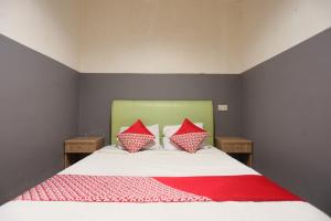 a bedroom with a bed with two red pillows at OYO 92988 City Room in Nagoya