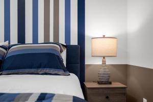 a bedroom with a bed and a lamp on a night stand at Super Deal - Brand New Themed 9BR Home near Disney in Kissimmee +44 photos
