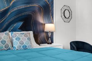 a bedroom with a blue bed and a chair at Super Deal - Brand New Themed 9BR Home near Disney in Kissimmee