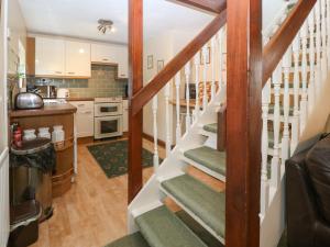 eine Küche mit einer Treppe, die zu einem Wohnzimmer hinaufführt in der Unterkunft The Cottage at Ty Newydd in Llanfairpwllgwyngyll