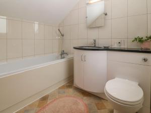 ein Badezimmer mit Toilette, Waschbecken und Badewanne in der Unterkunft The Cottage at Ty Newydd in Llanfairpwllgwyngyll + 18 Fotos